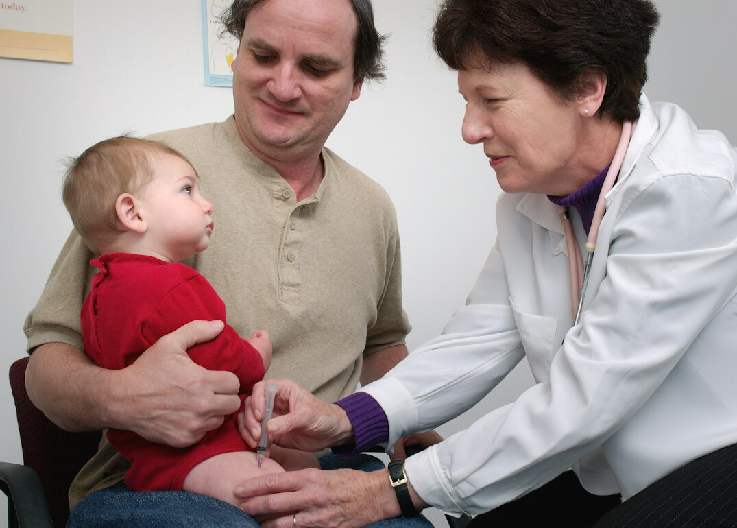 doctor administering vaccine to child